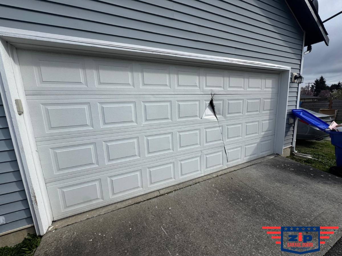 <i>Severe dent and puncture in the garage door panel causing misalignment.</i>